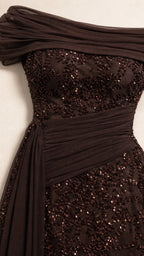 Close-up detail of draped off-shoulder neckline and sequin texture