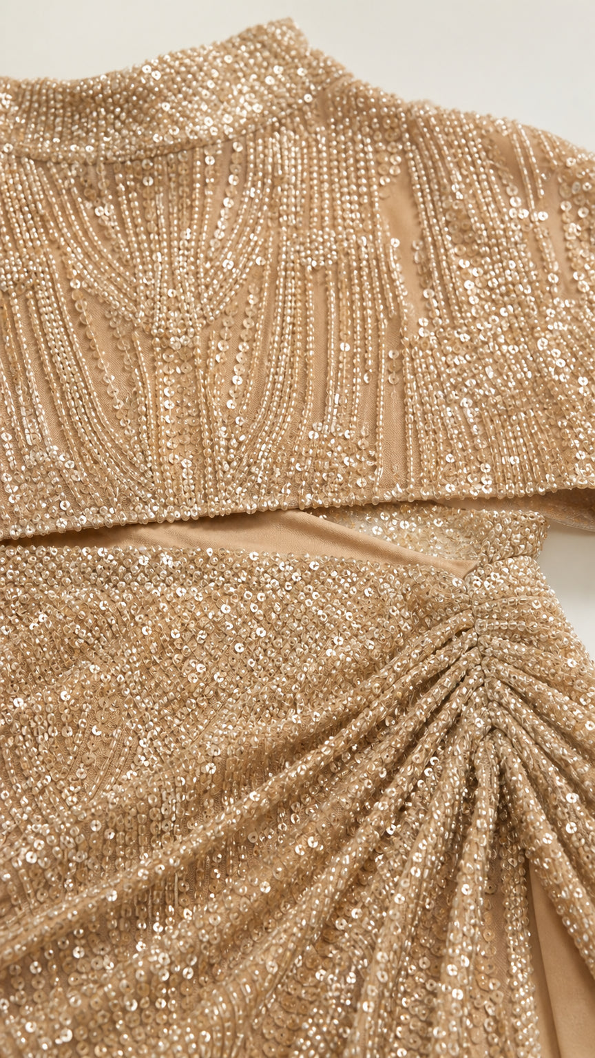 Close-up of champagne sequin fabric and ruched skirt detail