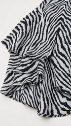 Close-up detail of layered ruffles on the zebra print fabric