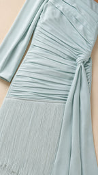 Close-up detail of ruching and fringe hem on light blue skirt
