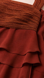 Close-up detail of metallic pleated bodice and chiffon tiers in Rust Red