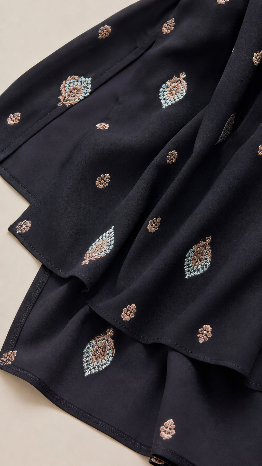 Close-up detail of the patterned fabric and hem on the black dress
