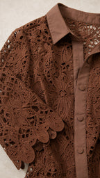 Close-up detail of brown lace collar, buttons, and sleeve hem