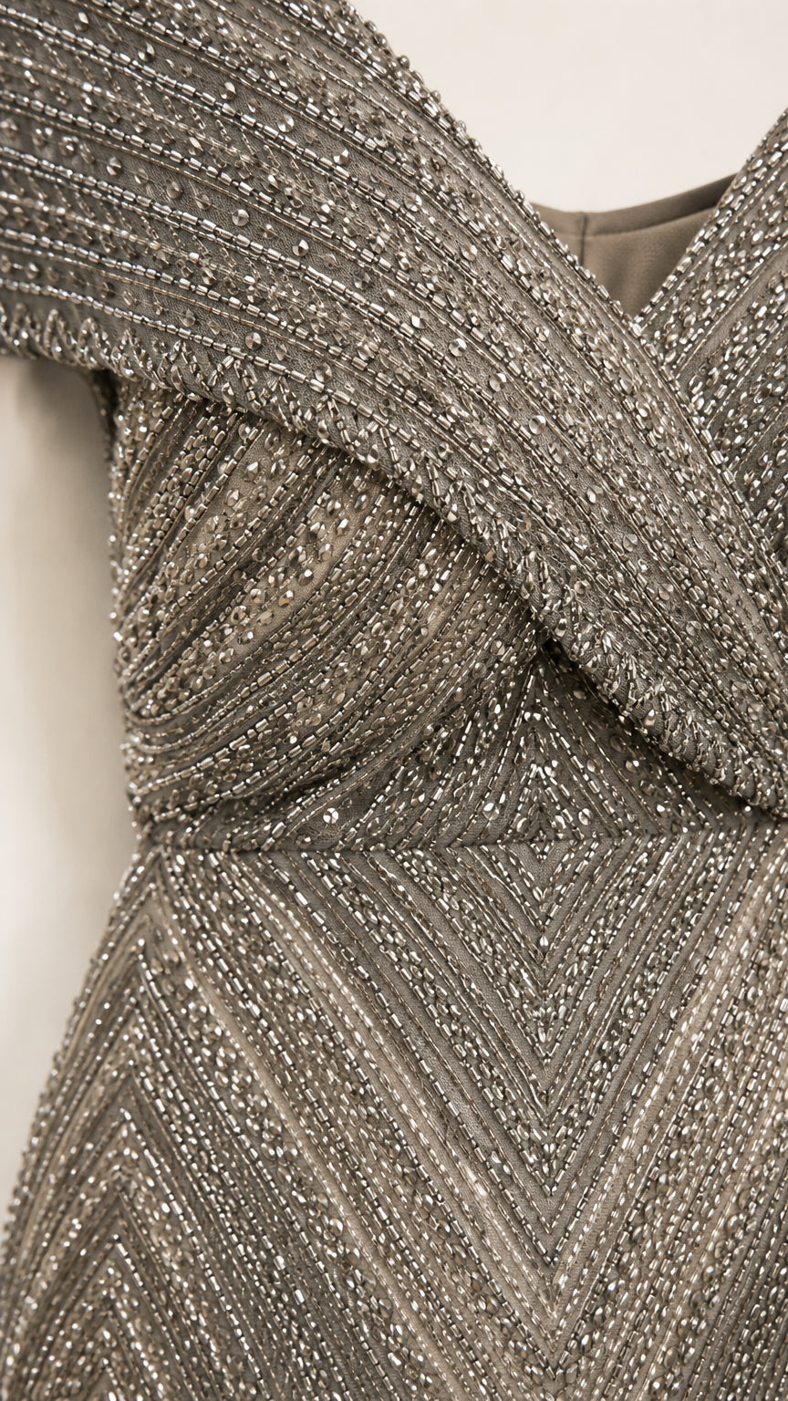 Close-up detail of the crossover V-neckline and beaded pattern