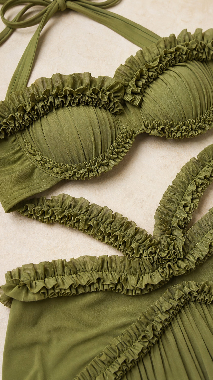 Close-up detail of the textured ruffles on the olive crop top and skirt waistband