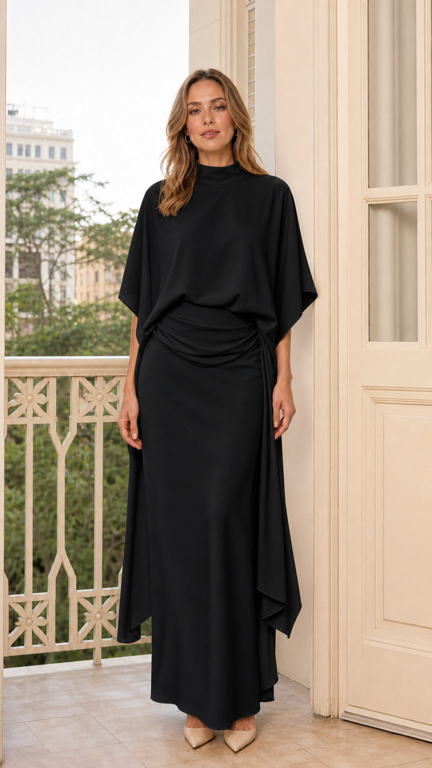 Front view of model in black draped mock neck maxi dress