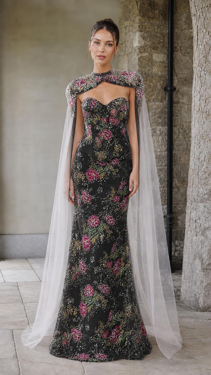 Front view of black floral embroidered corset gown with sheer cape