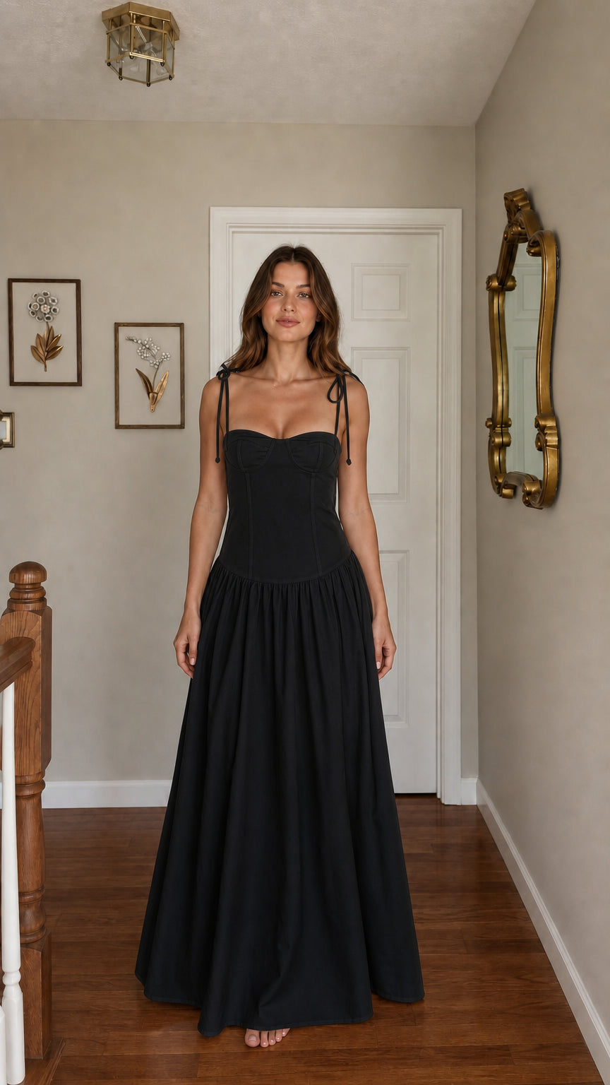 Front view of woman wearing black tie-strap corset maxi dress