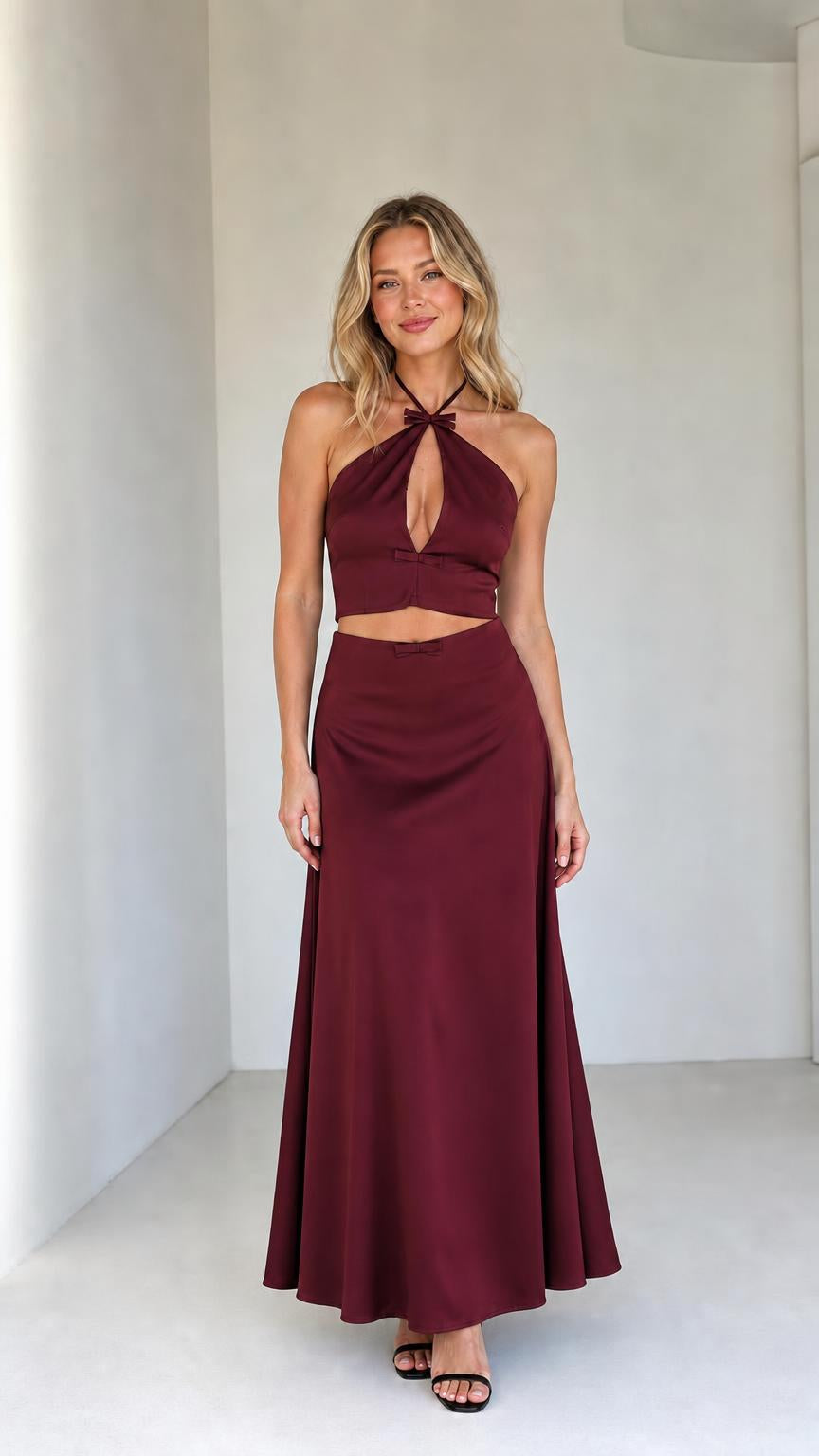 Model wearing burgundy satin halter crop top and maxi skirt set
