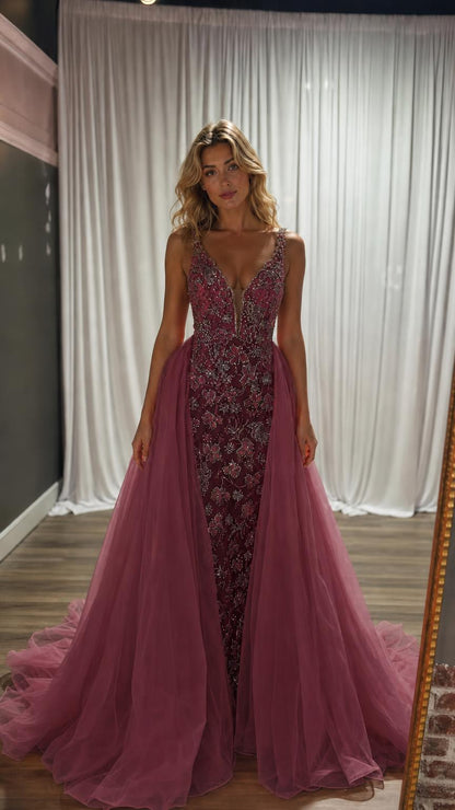 Model wearing deep plum evening dress with heavy beadwork and tulle overskirt