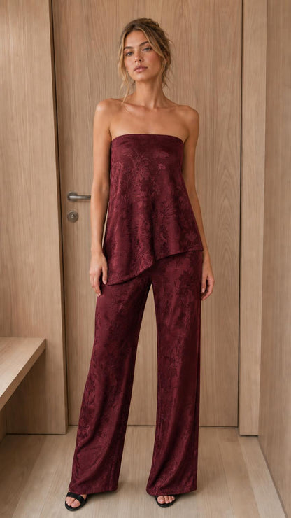 Model wearing burgundy strapless jacquard top and pant set
