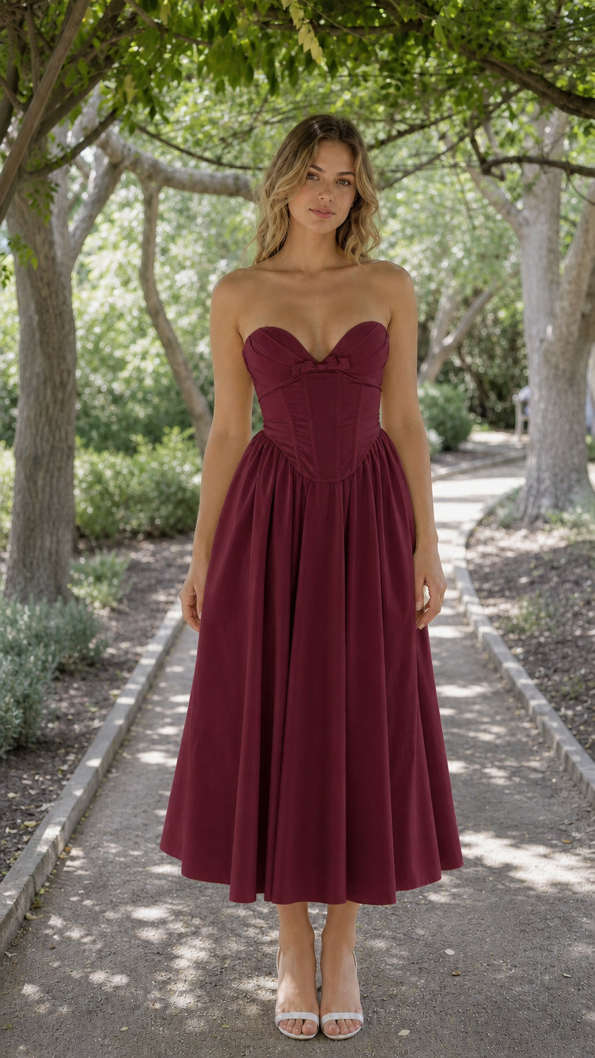 Front view of woman wearing burgundy strapless corset midi dress